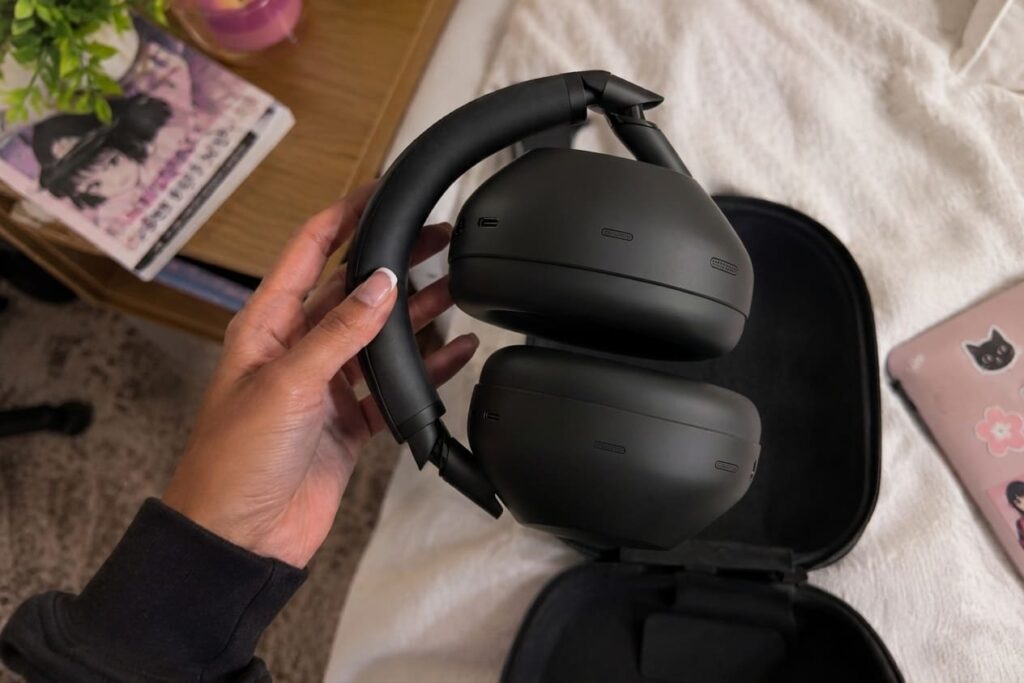 Un casque audio noir pliable dans la main